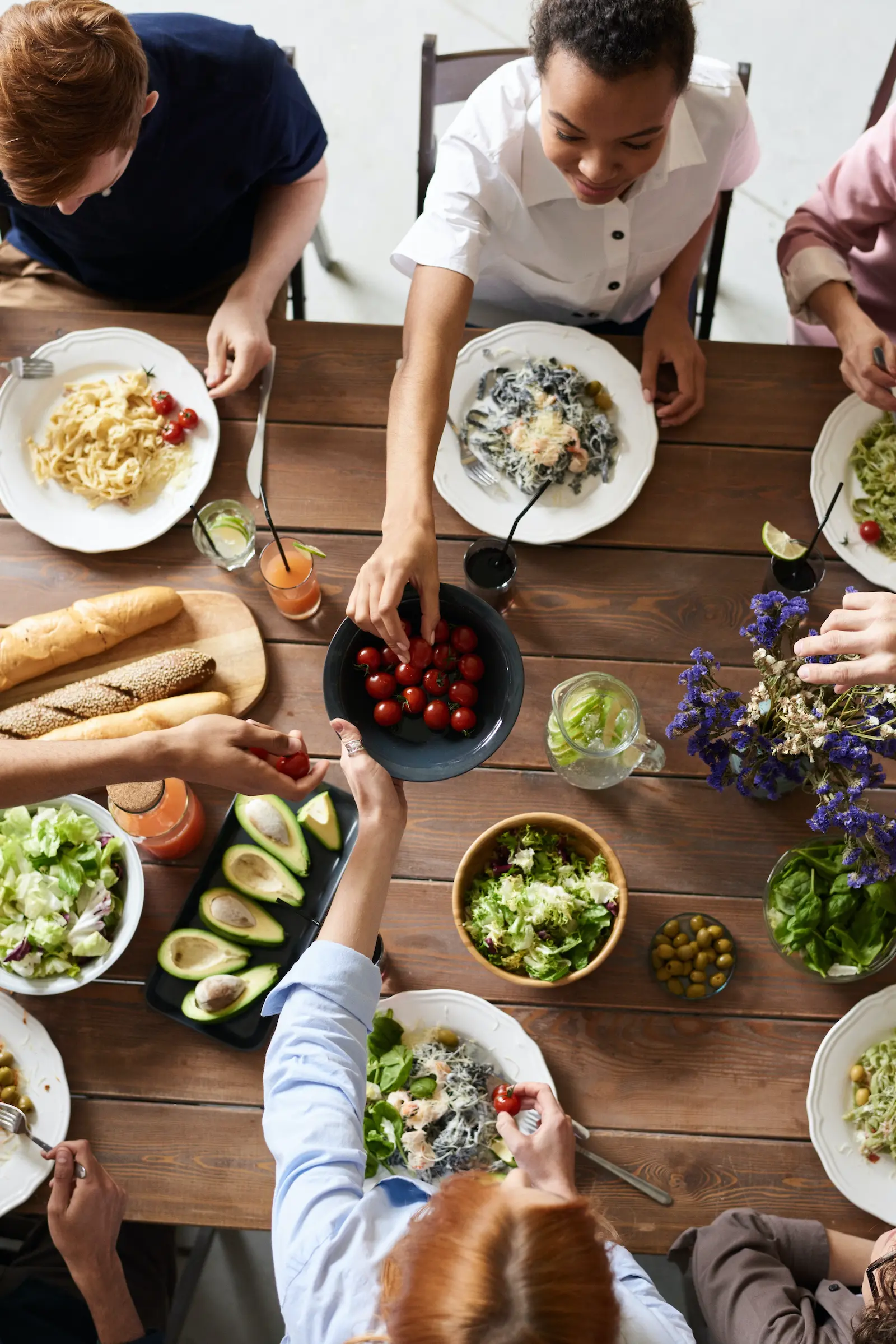 overhead view of a table with people sharing healthy colourful food