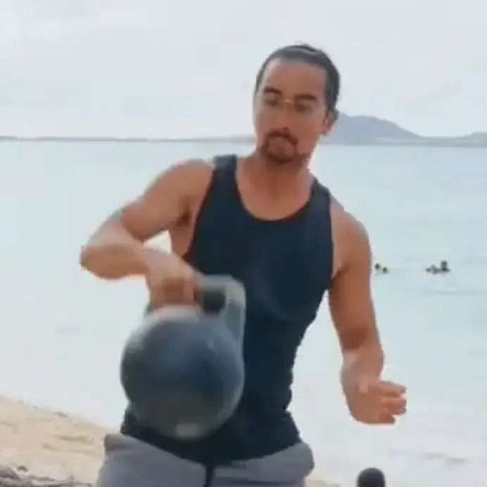 justin on beach with kettle bell